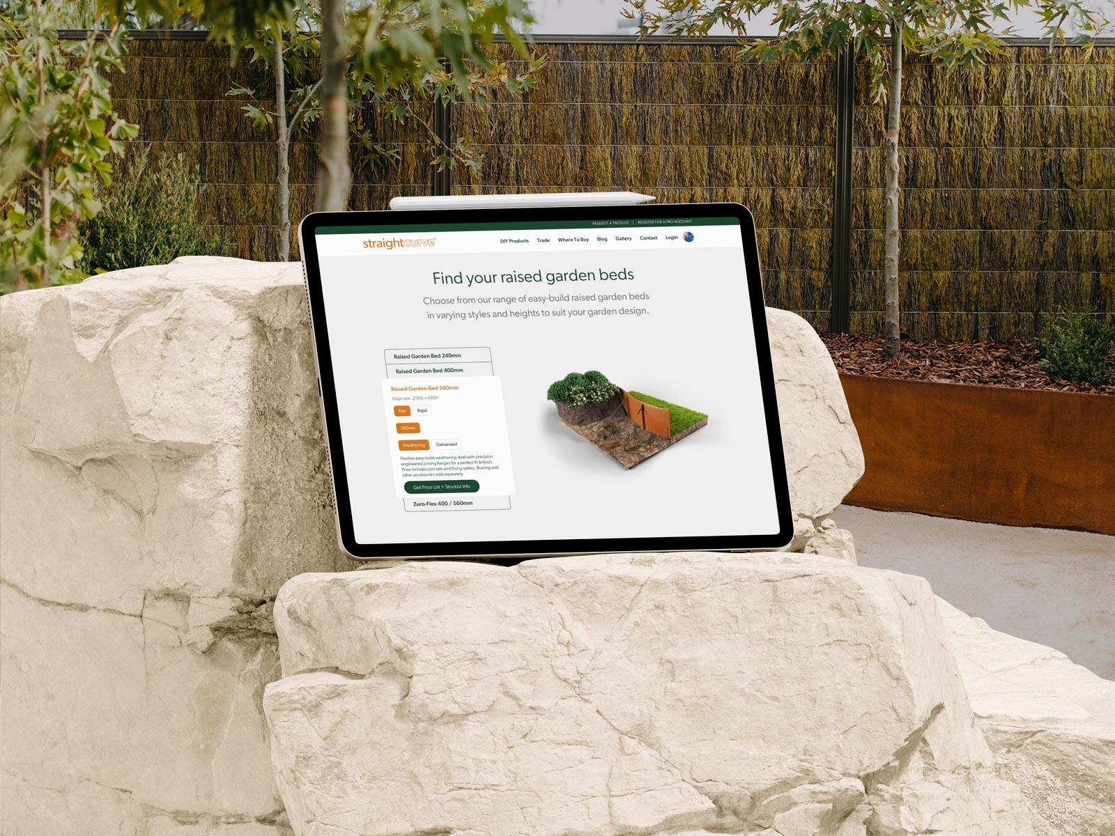 Straightcurve Website on iPad in a garden sitting on rocks